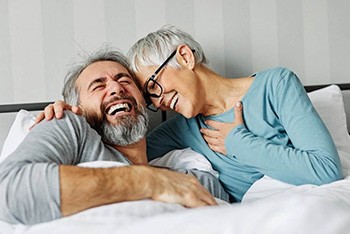 a mature couple with dentures laughing together